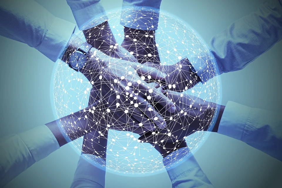Hands joined together beneath a global digital network